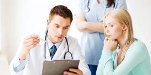 Multi-disciplinary medical specialist team reviewing patient treatment plan on a clipboard